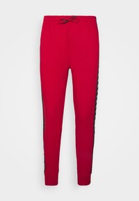 Rode sweatpants met elastische tailleband, verstelbaar trekkoord en zwarte zijstrepen met een herhaald patroon. Zacht, casual stof.