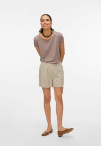 Lys lilla kortærmet top med en afslappet pasform, parret med beige stribede shorts og brune flade sko. Enkel, afslappet påklædning i neutrale farver.