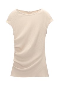 Haut beige à manches courtes en tissu côtelé et doux, avec un tombé décontracté et un détail drapé sur le côté. Encolure ronde avec une bordure étroite.