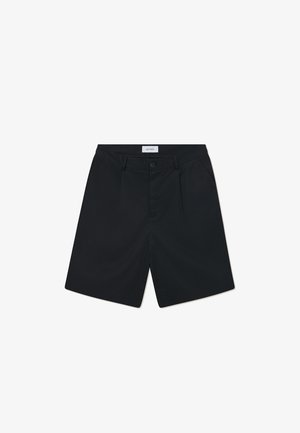 Pantalones cortos negros de tela con una textura suave. Las características incluyen un cierre de botón, dos pliegues frontales y una cinturilla estándar.