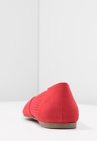 Červené semišové baleríny se zaoblenou špičkou a perforovaným designem na svršku. Světle hnědá podešev. Hladká textura, minimalistický styl.