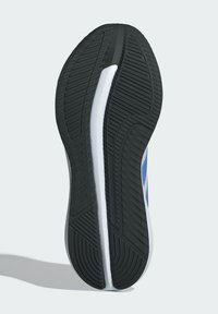 Semelle de chaussure en caoutchouc noir, dotée d'un motif de bande de roulement multidirectionnel, d'une semelle intermédiaire blanche et de accents bleus le long du côté latéral.