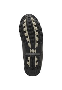 Semelle de chaussure robuste noire et beige avec des crampons profonds et le logo « HH » au centre, conçue pour l’adhérence et la durabilité.