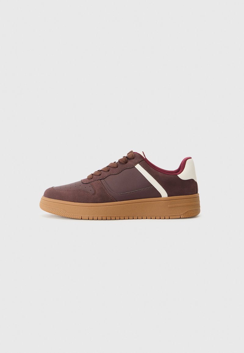 Braune Sneakers mit einer strukturierten Oberseite, Gummisohle, weinroten Akzenten und weißem Seitenpanel. Verfügt über runde Schnürsenkel und ein durch perforiertes Design an der Zehenpartie.