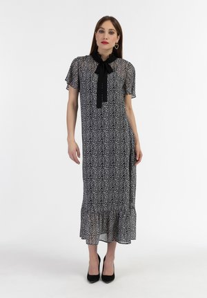 Schwarz-weiß bedrucktes Kleid mit kurzen Ärmeln, Rüschensaum, Schleifendetail und schwingendem Saum, aus leichtem Stoff gefertigt.