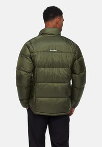 Olivgrüne Pufferjacke mit hohem Kragen, gesteppter Oberfläche und Logoprint auf der Rückseite. Glatte, glänzende Textur mit lässiger Passform.