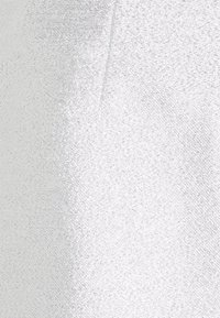 Tissu métallique argenté avec une texture lisse et un léger éclat, présentant une surface uniforme sans motifs ni accents visibles.