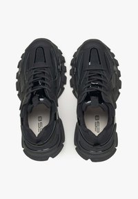 Schwarze Sportschuhe mit einem strukturierten Obermaterial, Mesh-Einsätzen und dicken Gummisohlen. Mit Schnürsenkeln und Logo auf der Innensohle.