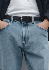 Light blue denim jeans with a straight cut, featuring a black leather belt. The fabric has a slightly faded texture and visible stitching details.