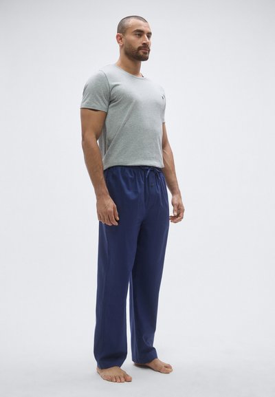 Szara bawełniana koszulka z okrągłym dekoltem oraz granatowe spodnie z sznurkiem w talii. Koszulka ma okrągły kołnierz; spodnie cechują się luźnym krojem i subtelnymi detalami szwów.