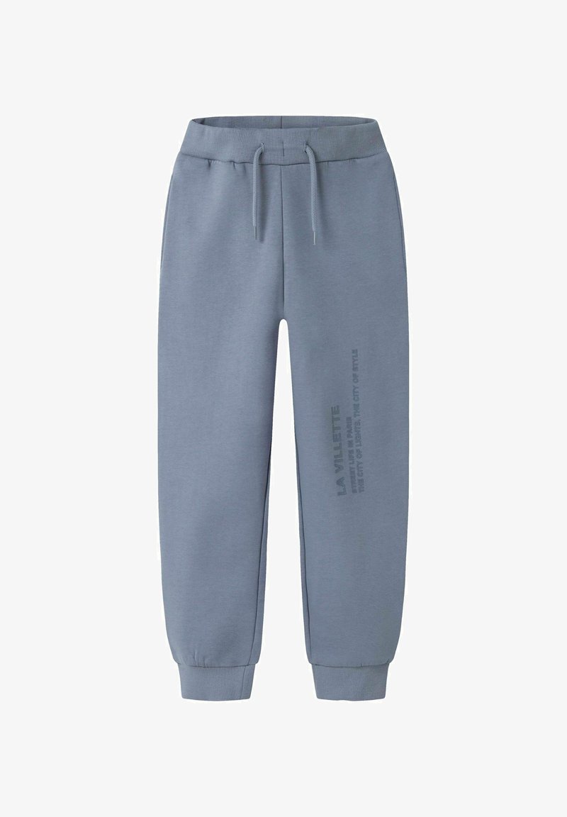 Pantalones de chándal azul claro, hechos de tejido suave, con una cinturilla ajustable y puños ceñidos. Presenta texto impreso a lo largo de una pierna.