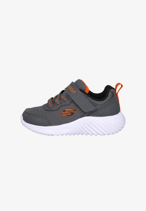 Zapatilla deportiva gris con acentos naranjas, parte superior de malla transpirable, cuello acolchado, correa ajustable y suela de goma texturizada blanca.