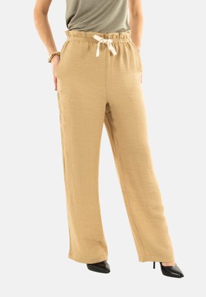 Beige linnenmix wijde broek met een trekkoord in de taille en zijzakken, met een gestructureerde afwerking. Gecombineerd met zwarte hoge hakken.