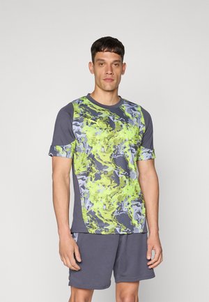 Activewear set featuring a short-sleeve, gray shirt with a multicolored green and blue abstract pattern, paired with gray shorts.