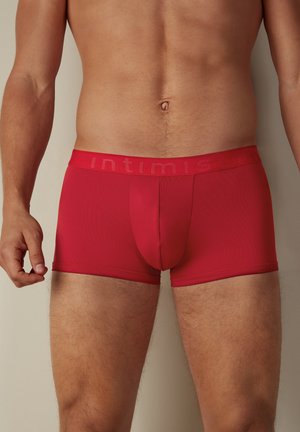 Rote Herren-Boxershorts aus glattem Stoff, mit enger Passform, elastischem Bund mit geprägt Branding und einer vertikalen Naht für zusätzlichen Halt.