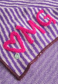 Gestreepte paarse en witte stof met roze pluizige geborduurde tekst "OMG" en een hart. Heeft een bruine gestikte rand en een kleine ronde hanger.