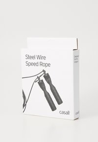 Μαύρο ατσάλινο σχοινί ταχύτητας σε λευκό κουτί. Διαθέτει υφασμάτινες μαύρες λαβές και καθαρή σήμανση προϊόντος. Σχεδιασμένο για αντοχή και απόδοση.