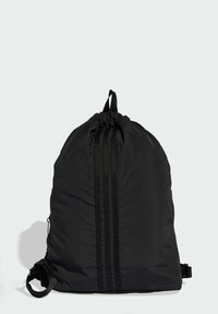 Sort snøre rygsæk lavet af letvægtsstof. Har lodrette sorte striber, justerbare stropper og en sidelomme med lynlås.