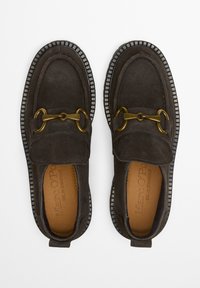 Dunkelgraue Wildleder Slipper mit runder Zehenform, ausgestattet mit einem goldenen Kettenakzent und einer strukturierten Gummi-Sohle mit einem kontrastierenden Rand.