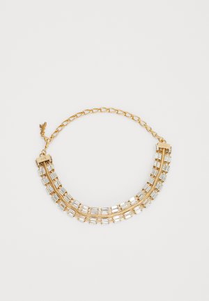 Auksinės spalvos karoliai, kuriame yra dvi išlenktos eilės skaidrių stačiakampių kristalų, sujungtų grandinėmis ir sagtimi.