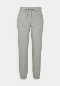Šedé tepláky vyrobené z měkké látky, s elastickým pasem na šňůrku a staženými kotníky. Logo "Converse" v bílé barvě na boku.