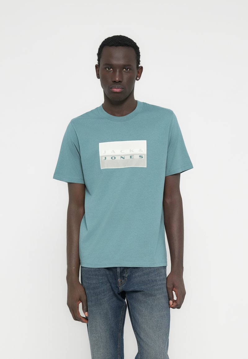Τυρκουάζ βαμβακερό t-shirt με κοντά μανίκια και στρογγυλή λαιμόκοψη, με ορθογώνιο λογότυπο σε λευκό και γκρι με την επιγραφή "JACK & JONES".