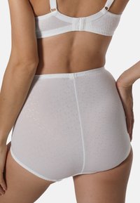 Weiße hochtaillierte Unterhose aus glattem Material, mit einem dezenten Punktmuster und kontrastierenden Paspeln entlang der Kanten, die eng anliegt.
