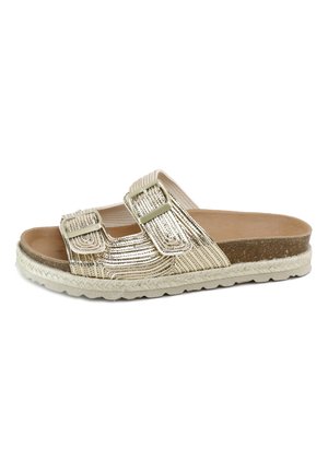 Sandalia tipo slip-on con dos tiras ajustables metálicas doradas, plantilla de corcho y suela exterior blanca texturizada con borde trenzado.