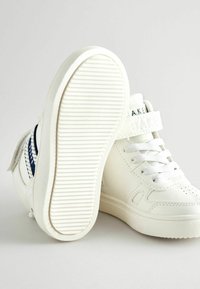Weiße High-Top-Sneaker aus glattem Leder mit einer strukturierten Gummisohle. Verfügt über einen Klettverschluss und marineblaue Akzente an der Seite.