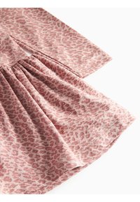 Rosa stoff med leopardmønster, med innsamlede detaljer i midjen og korte ermer. Glatt tekstur og avslappet stil.