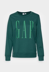 Sudadera verde de manga larga, con un gran logo de "GAP" en verde más claro. Confeccionada en tejido suave, tiene un cuello redondo y puños acanalados.