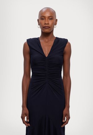 Navyblauwe mouwloze jurk met een V-hals, voorzien van gerimpeld detail bij het lijfje en een vloeiende silhouet, gemaakt van zachte, rekbare stof.