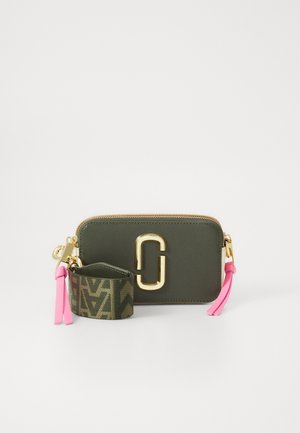 Olijfgroene tas met gouden hardware, rits sluiting en een gestructureerd oppervlak. Inclusief roze franjes en een patroon sleutelhanger.