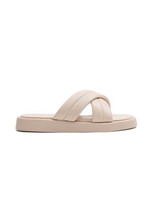 Sandalia tipo slide beige pálido con diseño de tiras cruzadas, suela plana y textura suave. Estilo minimalista sin hebillas ni adornos visibles.