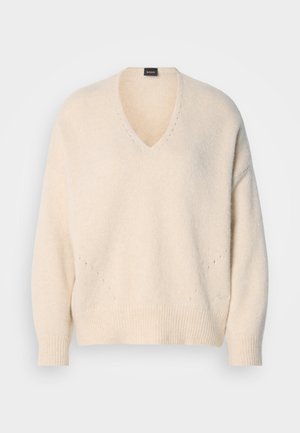 V-neck, long-sleeve sweater in soft cream-colored knit. Features ribbed cuffs and hem, with subtle open stitch detailing at the front.