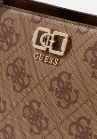 Borsa a tracolla marrone con motivo a fantasia e superficie testurizzata, dotata di fibbia in ottone dorato e logo impresso sul davanti.