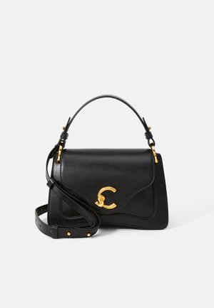 Sac à main en cuir noir au design structuré, avec des accessoires en métal doré, une bandoulière réglable et un logo en lettres bien en vue sur le devant.