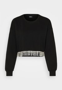 Sweatshirt noir court à manches longues et encolure arrondie, avec une frange perlée sur l'ourlet. Tissu doux avec une texture lisse.