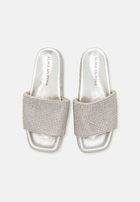 Sandalias de dedo descubiertas con una base metálica plateada y una amplia correa texturizada decorada con strass en un patrón de rejilla.