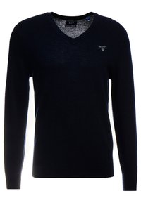 Marinblå V-ringad tröja gjord av mjukt stickat material. Har långa ärmar och en liten logotyp på bröstet. Klassisk passform och enkelt design.