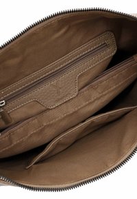 Brown leather bag interior with multiple zippered and open compartments, fabric lining, and visible stitching details.