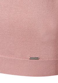 Helles rosa Strickstoff mit gerippter Textur, ausgestattet mit einem kleinen silbernen Logoetikett am unteren Rand.