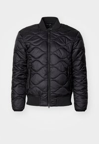 Giacca bomber nera trapuntata con zip frontale, colletto e polsini a costine. Presenta tasche verticali con zip e una superficie liscia e lucida.
