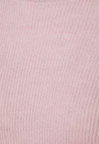 Tissu tricoté rose clair avec une texture côtelée verticale, tissé serré. Apparence douce avec une finition extensible et lisse.