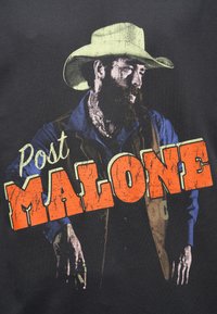 Tricou negru cu un grafic al unui bărbat cu pălărie de cowboy și barbă, textul spune „Post MALONE” în litere portocalii și galbene cu efect uzat.