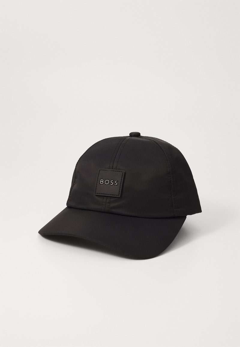 Gorra negra de tela con una textura suave. Presenta una corona redondeada, un visera rígida y un parche de logo cuadrado con "BOSS" en relieve.