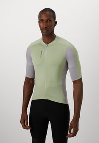 Kurzarm-Radsporttrikot in Hellgrün und Grau, aus strukturiertem Gewebe, mit einem Reißverschluss auf der Vorderseite und einem taillierten Design.