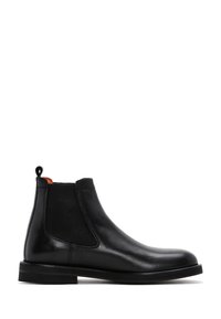 Stivale Chelsea in pelle nera con pannelli elastici laterali, linguetta sul tallone, punta arrotondata e tacco basso impilato.