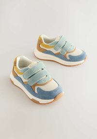 Zapatillas multicolor con parte superior de malla y detalles en ante en azul claro, beige y mostaza, aseguradas con dos tiras de velcro.