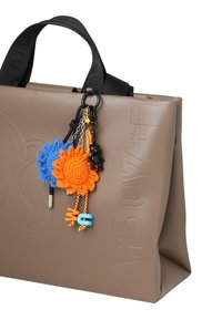 Hnedá syntetická taška na rameno s reliéfnym textom, ozdobená farebnými háčkovanými kvetmi a malými dekoratívnymi prvkami, ako sú medveď a písmená.